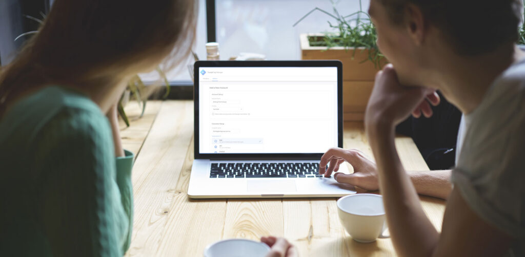 Business Colleagues Setting Up Google Tag Manager on a Laptop