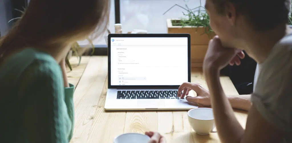 Business Colleagues Setting Up Google Tag Manager on a Laptop